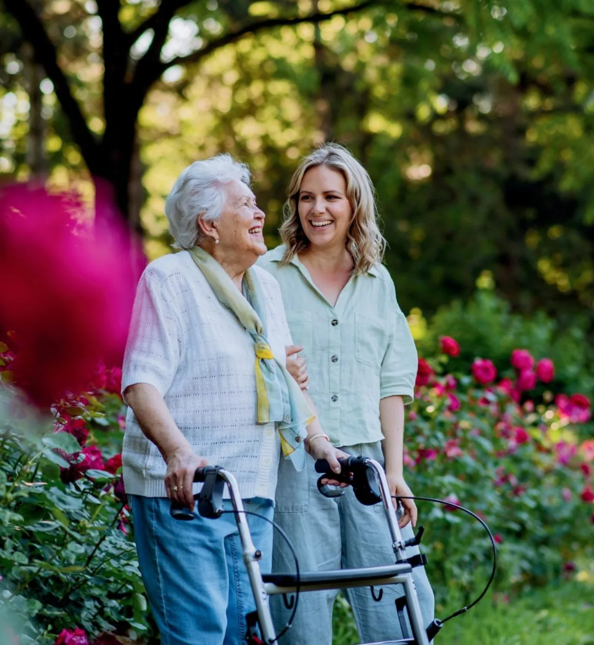 A Visiting Angels carer walking with a client in a garden